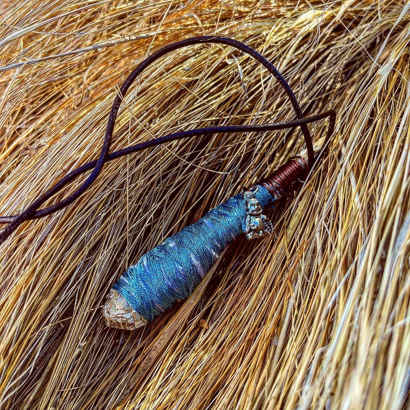 Sparkle Baby Blue sage necklace pendant, this is a photo of Sage jewelry made by Paul Adrian Moon, this specific sage piece has a mini silver sitting buddha Pendant, Paul Adrian Moon is also a photographer in Southern California and graphic artist, traveling and wrapping Sage necklaces along his journey, making portable smudging sage wear. REAL White sage nnecklaces, candles, wire wrapping Sage, pendants, crystals and more. Burnable Sage. Handmade and natural jewelry 